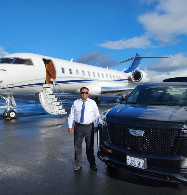 Fahad - CEO of All Bay Limousine, in a blue shirt standing between a private jet and black Escalade
